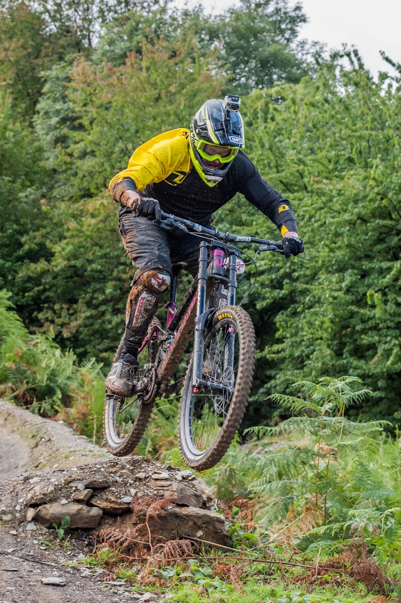 man riding on gray full-suspension mountain bicycle during daytime